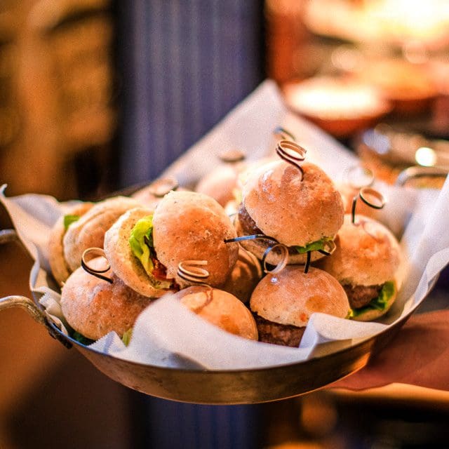 Sussex Wedding Caterer Festival food for the evening, Weddings Receptions or private parties and celebrations. The image shows a pile of sumptuous burgers being shared during the evening at a wedding party. Evening food