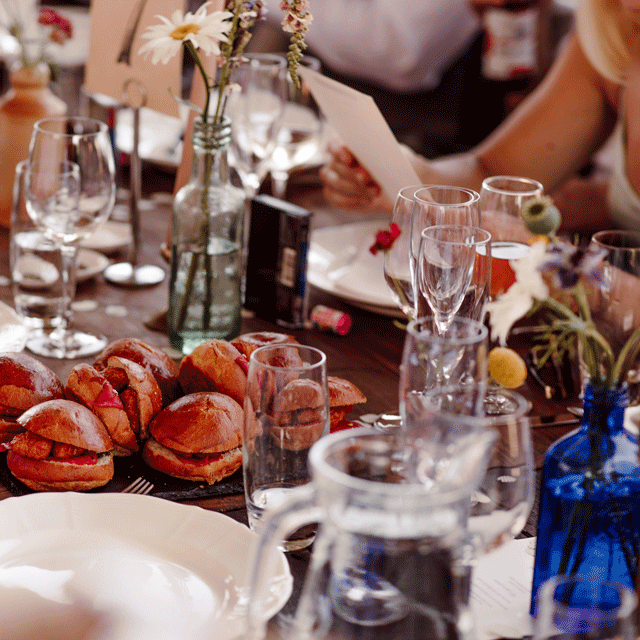 A celebration table of sliders and wine glasses leading to our web-form contact page
