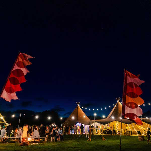 Lewes East Sussex Party Field Festival Style Venue Tents and Waving Flags at night with Festoon Lights